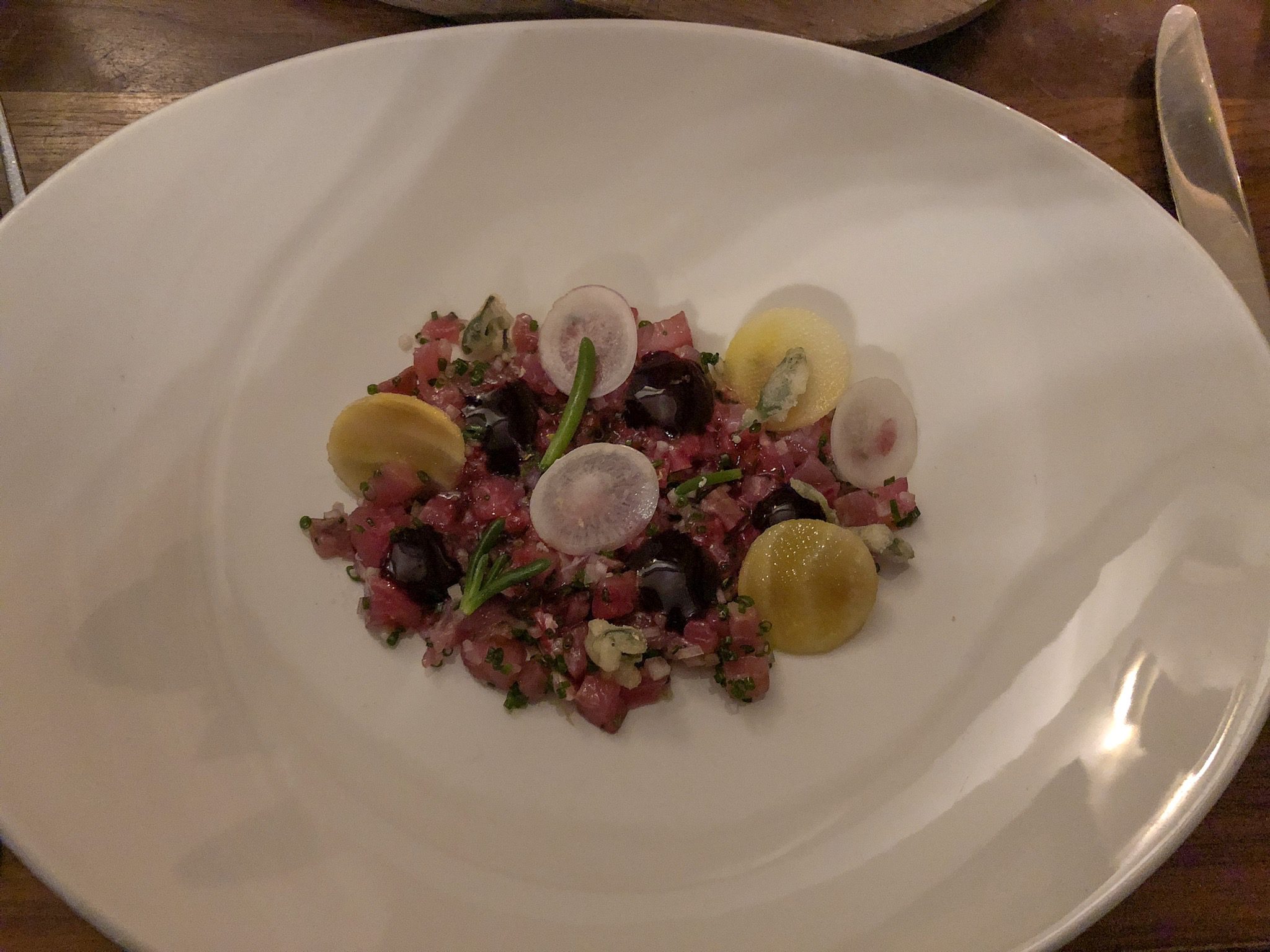 Beetroot Cured Sea Bass on a white plate