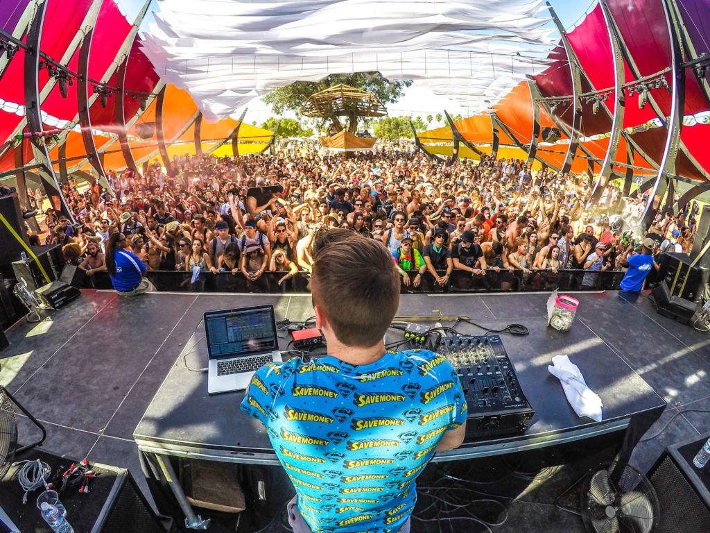A picture from a DJ booth on a stage at af estival facing towards the crowd