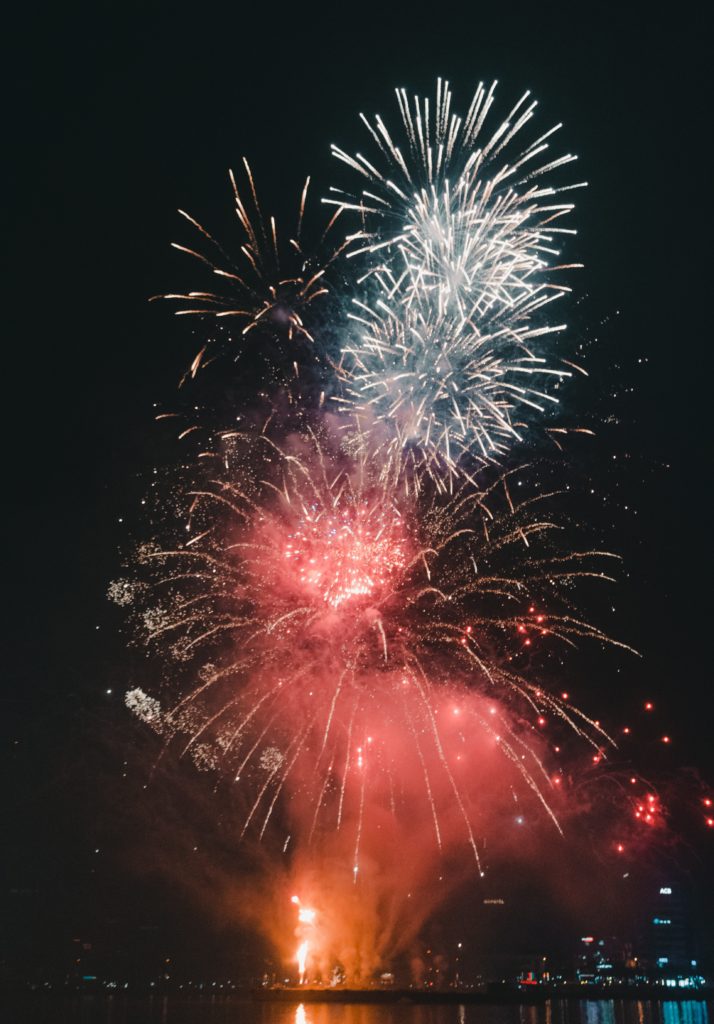 A big Firework display above a river at a festival