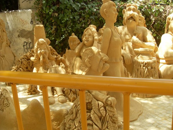 Sand Sculptures behind a yellow rail