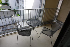 A shot of the Balcony, there is a metal table with two chairs
