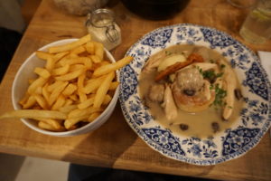 A large bowl of chips next to a bowl of chicken stew