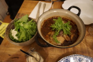 A large bowl of green salad next to Sassys Beef stew