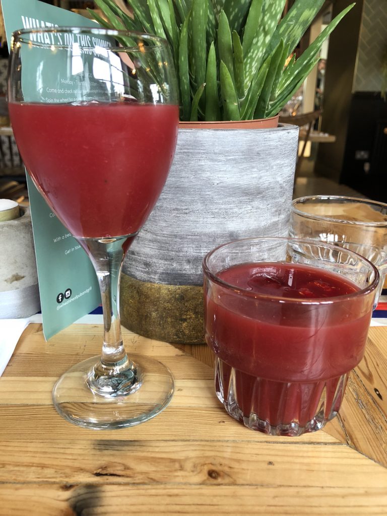 Two Blood red cocktails, one in a small glass and one in a wine glass