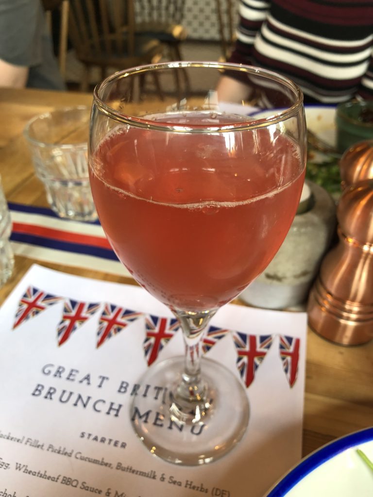 A light pink Cocktail in a wine glass