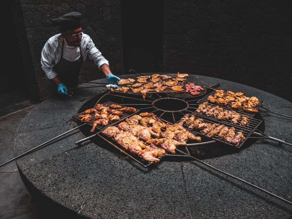 A man is cooking chicken over a volcanic heat vent