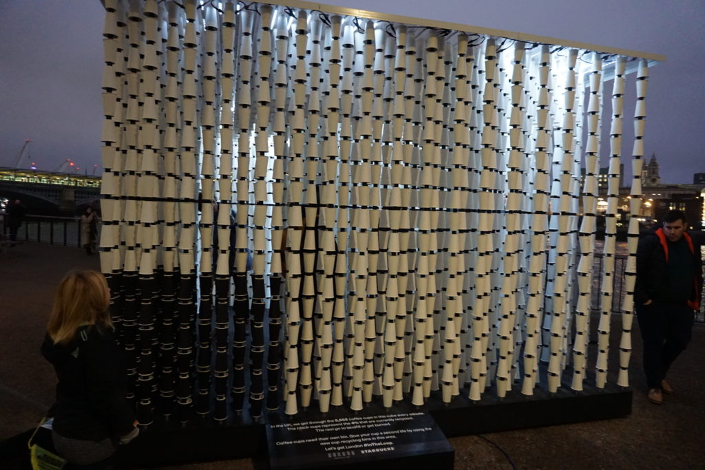 a cube of coffee cups, most are white cups meaning they are not recycled and a small corner have black cups which are the % recycled