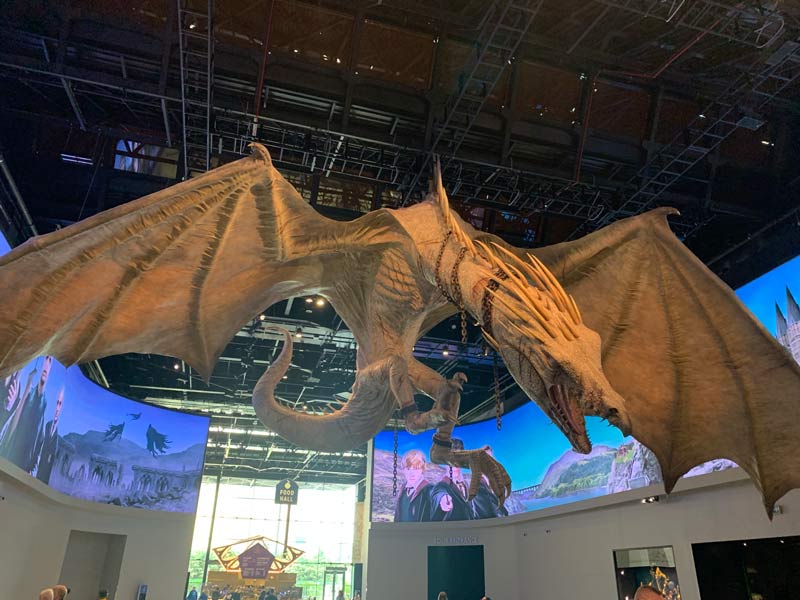 A brown dragon with his mouth open, hanging from the ceiling