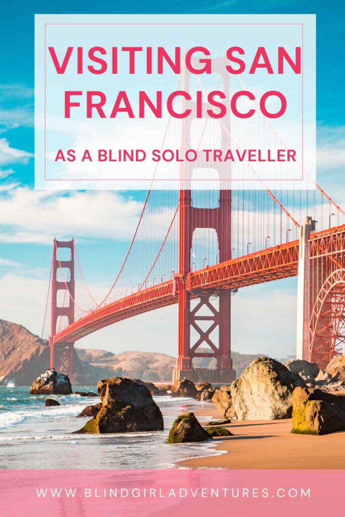 The pin for this post. A photo of the Golden Bridge taken from below, on a sunny day. On top there is a white box with "San Francisco as a Blind Solo Traveller" written on it. At the bottom there is a pink label with the URL of the website written on it with white letters. 